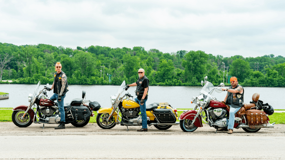 Jon Jansen, Dan Matzdorff, and Pete Leehey - The Biker Lawyers Personal Injury Attorneys - stand with their motorcycles next to a river outside of Cedar Rapids, Iowa