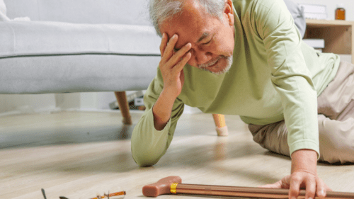 Image of an elderly man on the floor with his cane after a slip and fall.